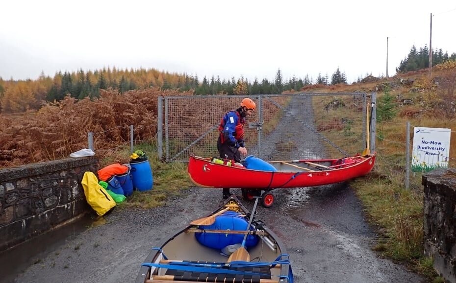 A person in a red canoe Description automatically generated