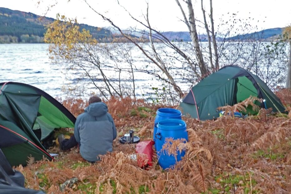 A person sitting next to a tent Description automatically generated