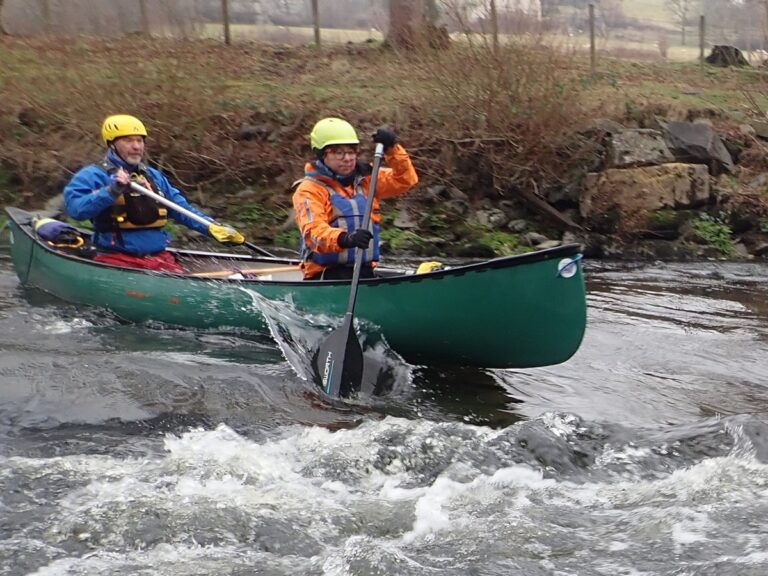 Two people canoeing in a fast river