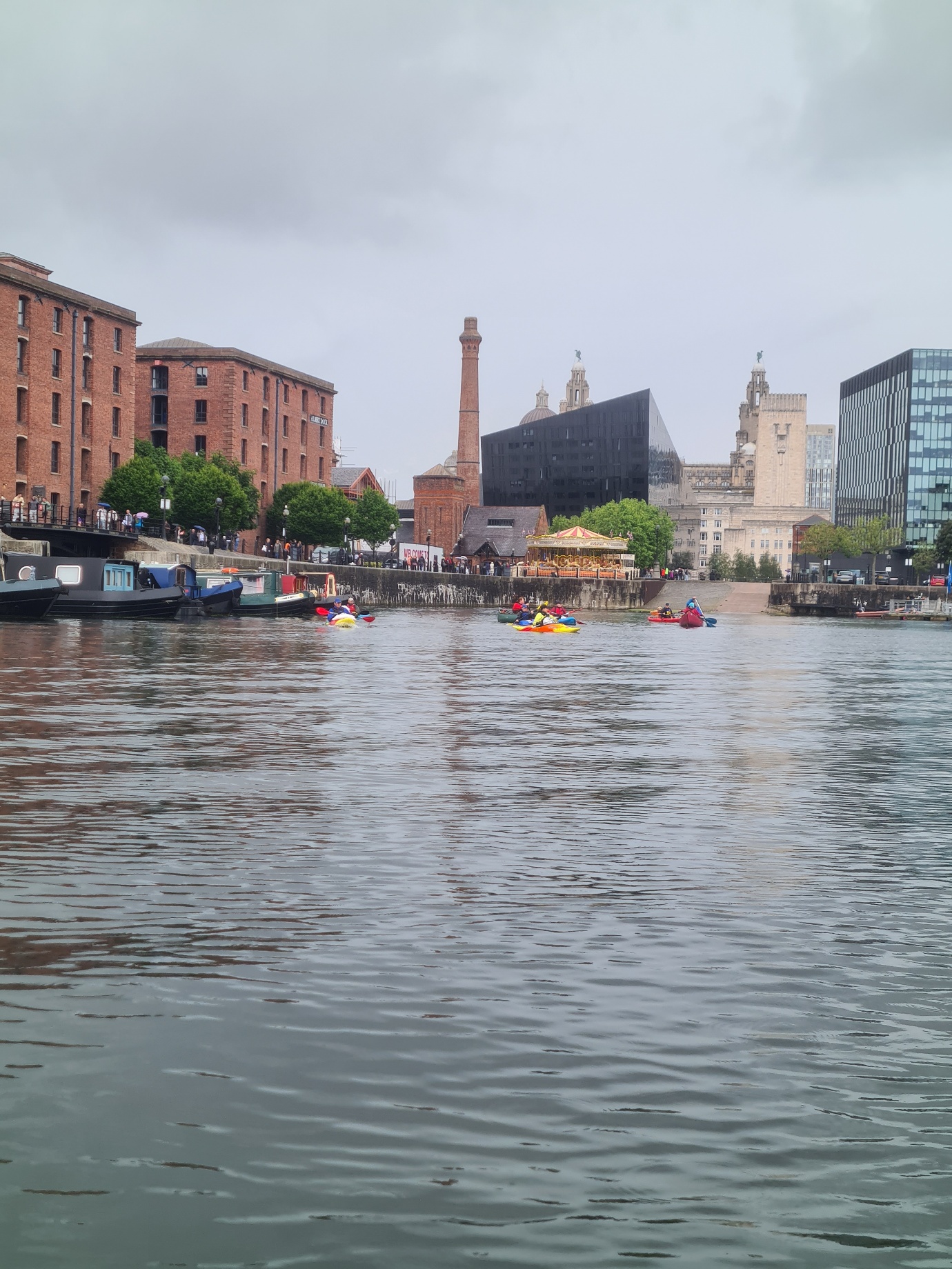A body of water with boats and buildings in the backgroundAI-generated content may be incorrect.