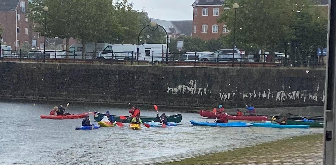 A group of people in kayaks on a riverAI-generated content may be incorrect.
