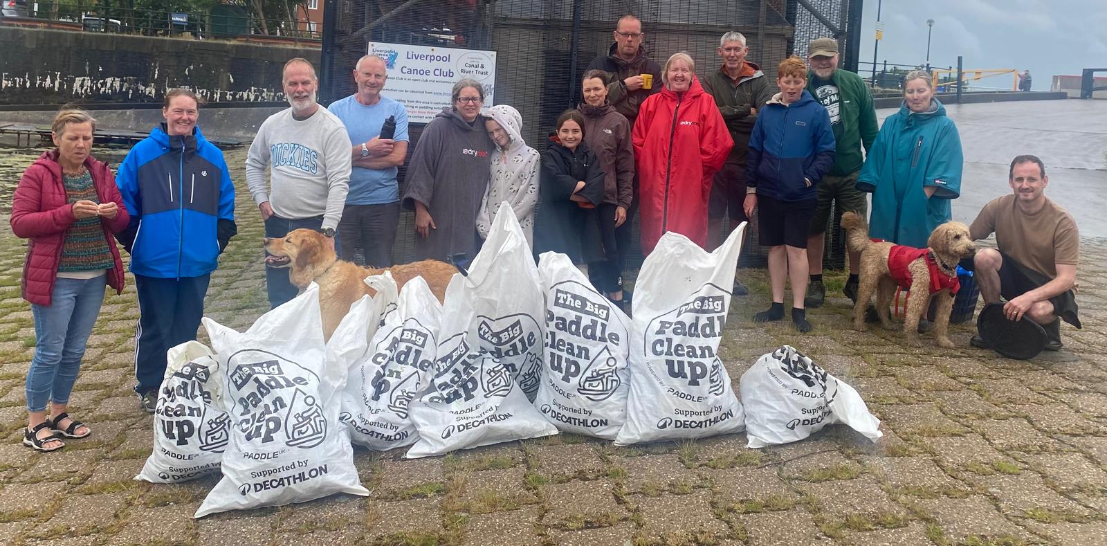 A group of people standing next to bags of garbageAI-generated content may be incorrect.