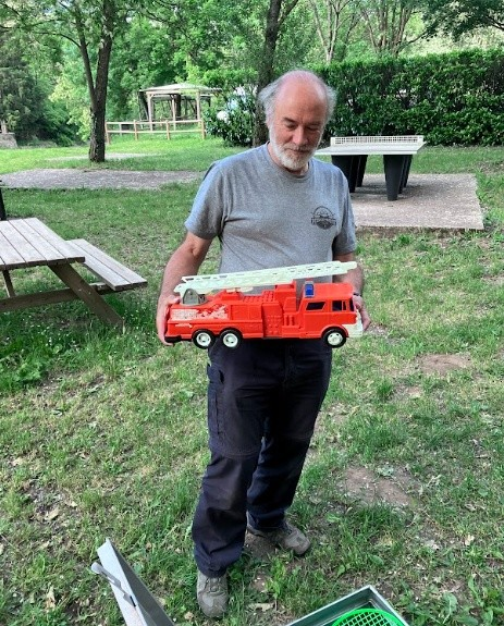 A person holding a toy fire truck AI-generated content may be incorrect.
