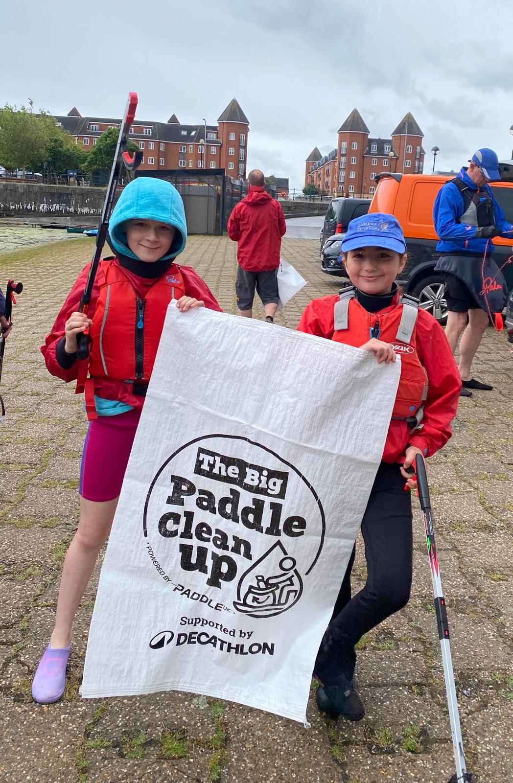 Two girls holding a sign and polesAI-generated content may be incorrect.