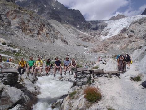A group of people sitting on a bridge Description automatically generated