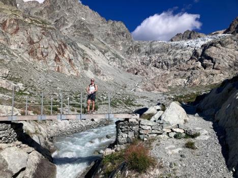 A person standing on a bridge over a river Description automatically generated