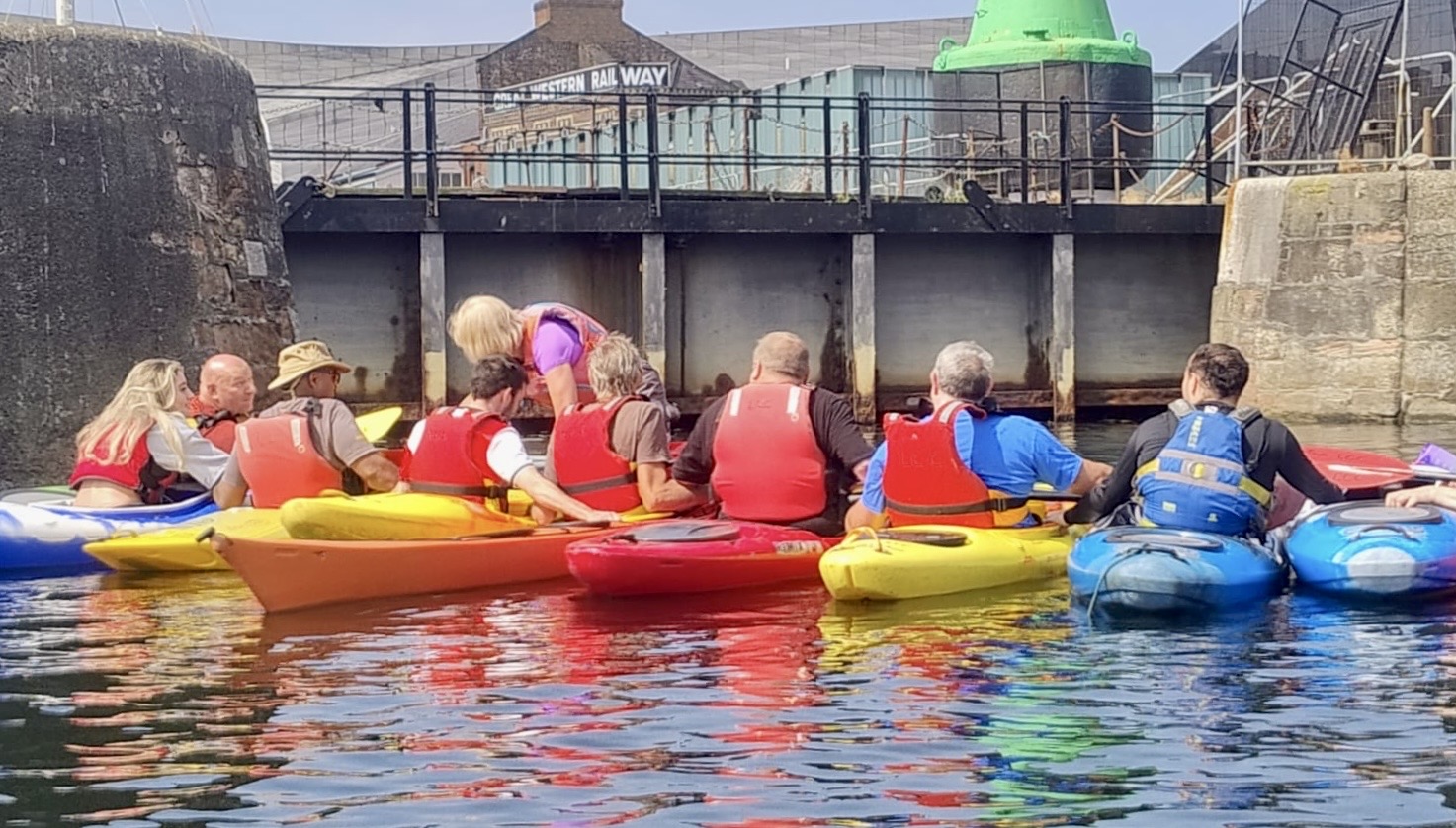 A group of people in kayaks on a riverAI-generated content may be incorrect.