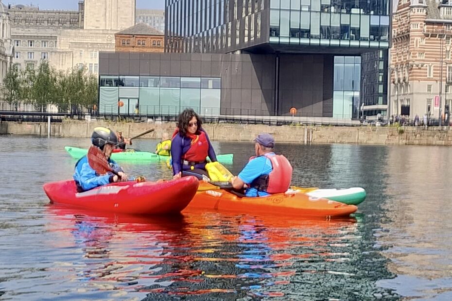 A group of people in kayaks on water AI-generated content may be incorrect.
