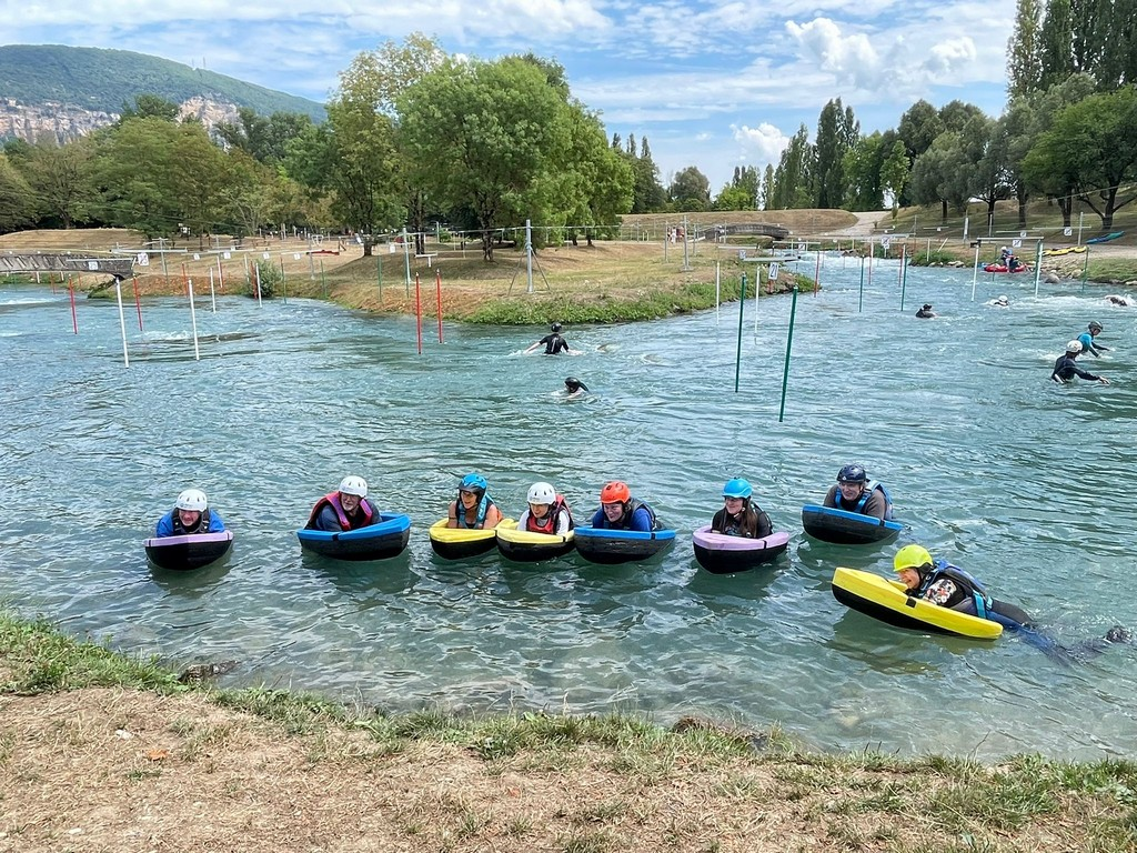 A group of people in small boats in a body of waterAI-generated content may be incorrect.