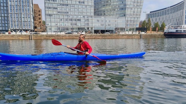 A person in a blue kayakAI-generated content may be incorrect.