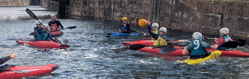A group of people in kayaksAI-generated content may be incorrect.