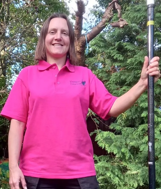 A person in a pink shirt holding a pole AI-generated content may be incorrect.