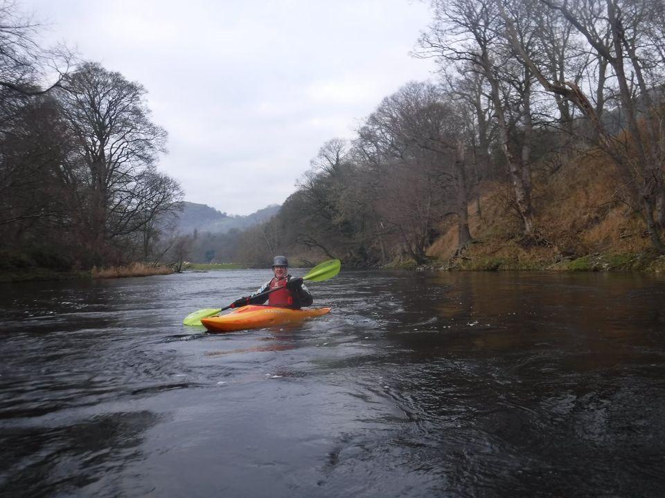 A person in a kayak on a river with trees on either side

Description automatically generated with medium confidence