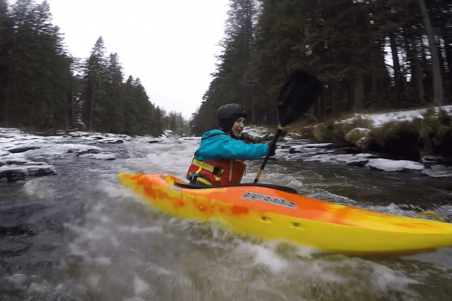 A person in a kayak on a river Description automatically generated with low confidence