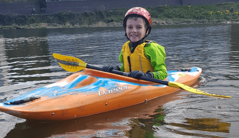 A child in a kayak Description automatically generated with medium confidence