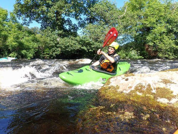 A person kayaking on a river Description automatically generated with low confidence