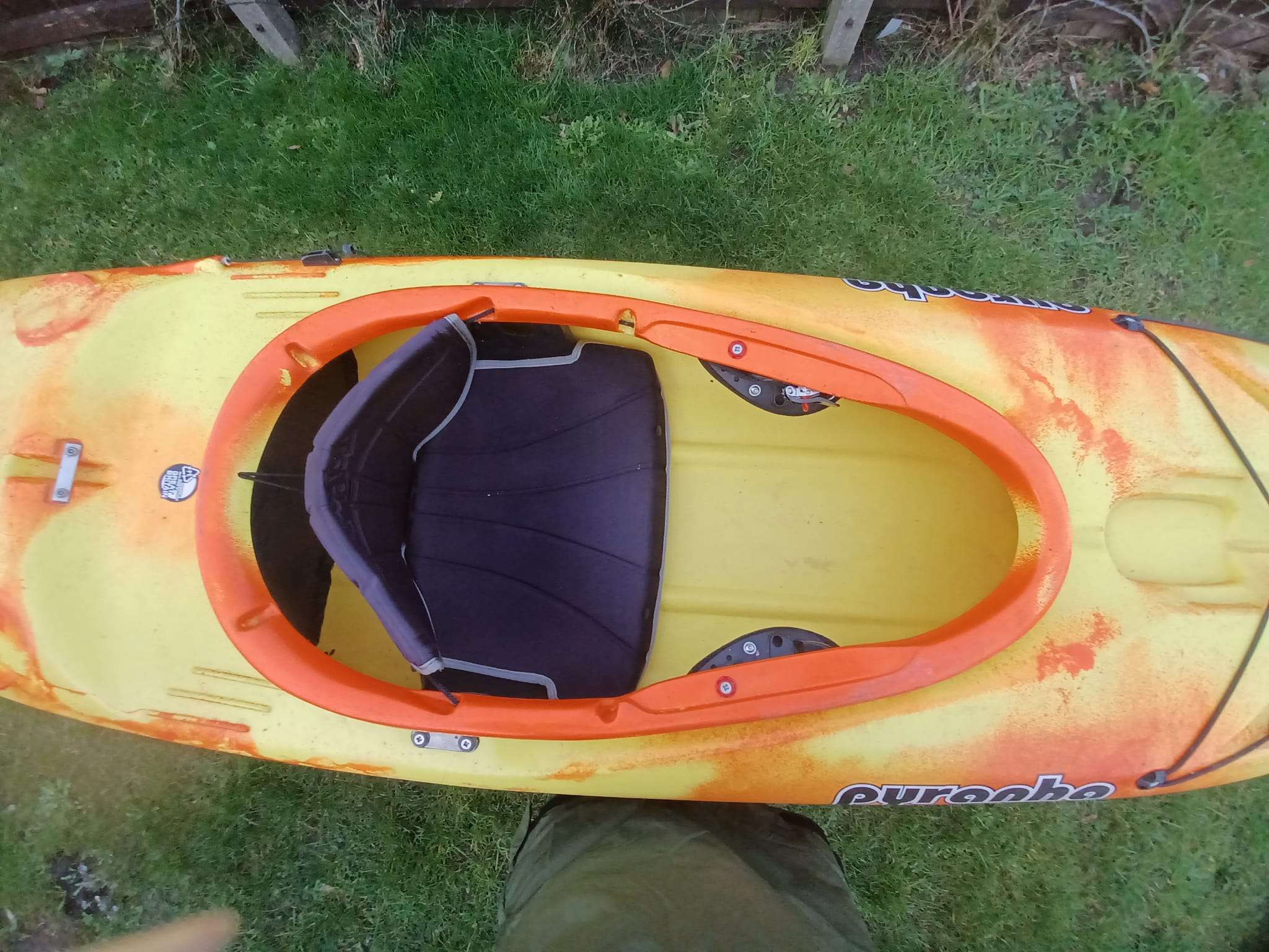 A yellow and orange kayak on grass

Description automatically generated